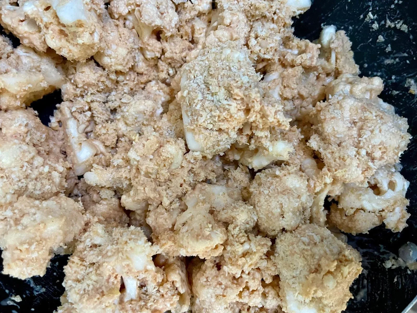 Step 3, photo 2: Add the cauliflower pieces and fold gently to coat them evenly in the batter.